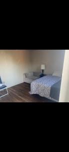 a bedroom with a bed and a table with a lamp at Leo's place in Rosarito Beach