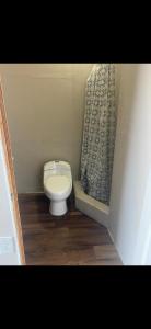 a small bathroom with a toilet and a curtain at Leo's place in Rosarito Beach