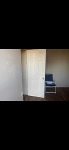 a room with a white door and a blue chair at Leo's place in Rosarito Beach