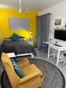 ein Schlafzimmer mit einem Bett und einer gelben Wand in der Unterkunft Die Ateljee in Glentana