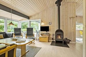 ein Wohnzimmer mit Kamin, Couch und Tisch in der Unterkunft 1474 Aakirkeby - Boesparken 20 in Vester Sømarken