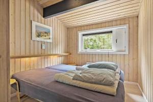 ein großes Bett in einem Zimmer mit Fenster in der Unterkunft 1474 Aakirkeby - Boesparken 20 in Vester Sømarken