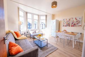 una sala de estar con un sofá y una mesa en Spacious Modern & High Ceiling One Bedroom Apartment, en Cardiff