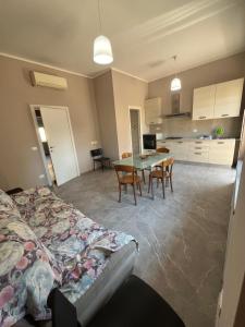 Una sala de estar con una mesa y una cocina. en Appartamento Fabbricotti, en Livorno