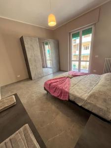 Un dormitorio con una cama grande y dos ventanas. en Appartamento Fabbricotti, en Livorno