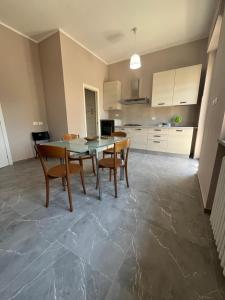 Una cocina con mesa de comedor y sillas. en Appartamento Fabbricotti, en Livorno 30 fotos más