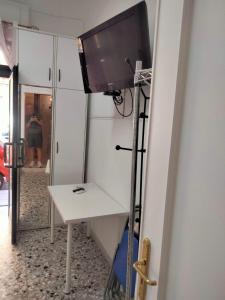 a television on a stand in a room with a table at Dolce Riposo in Trani