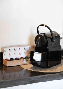 a tea kettle on a counter next to a box of wine at Appart luxe arya in Fès