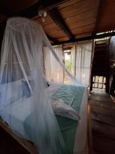 a bed with a mosquito net in a room at Mangle House Cabañas Ladrilleros in Buenaventura