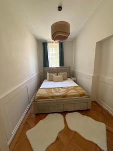 a bedroom with a bed and two rugs at V&V La Vie Est Belle in Neuchâtel