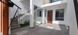 a white house with a staircase and a bike at Apart Hotel Bottger in Tacna