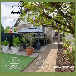 a garden in front of a house with a black umbrella at La maison des Ducs, terrasse, BBQ, Proche centre in Nevers