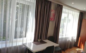 a table in front of a window with a wine glass at Stropi Apartment Daugavpils in Daugavpils
