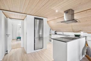 a kitchen with a stainless steel refrigerator and wooden ceilings at 4791-Ronne-Smedegardsvej-32 in Rønne +15 photos