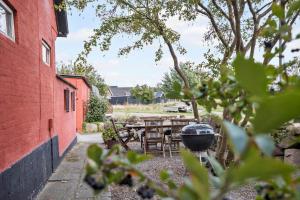 a patio with a grill and a table and chairs at 4791-Ronne-Smedegardsvej-32 in Rønne