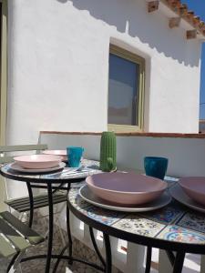 two tables with plates and a cactus on them at Casa griega segunda linea del mar in Oliva