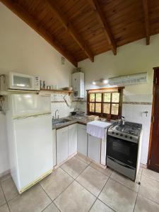 una cocina con estufa y microondas en Cabañas Ruca Alihuen, en La Cumbrecita