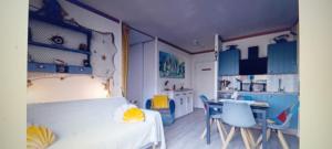 a room with a bed and a kitchen with blue cabinets at Studio cabine centre ville in Arcachon