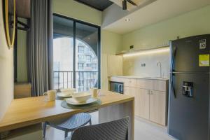 Una cocina con una mesa con sillas y un refrigerador. en BRENT 30 Living, en Medellín