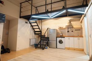 a laundry room with a refrigerator and a staircase at Kolman Apart in Saint Petersburg