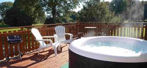 a hot tub on a deck with two chairs at Rouge - 3 star ground floor apartment in Mantilly