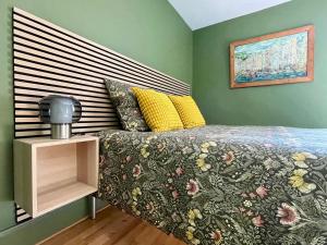 a bedroom with a bed with a floral comforter at La Maison Le 14 - Un Jardin en Ville in Auxerre