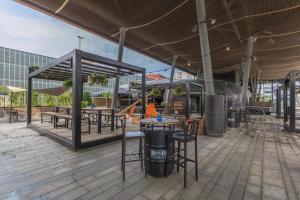 a patio with tables and chairs in a building at Leonardo Hotel Almere City Center in Almere