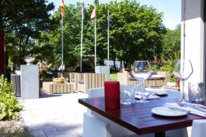 un tavolo con sedie e bicchieri da vino su un patio di Leonardo Royal Hotel Den Haag Promenade a L'Aia