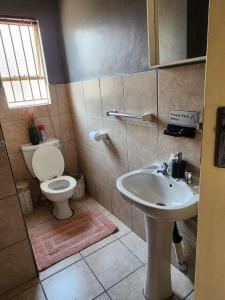 a bathroom with a toilet and a sink at Pearl palace in Polokwane