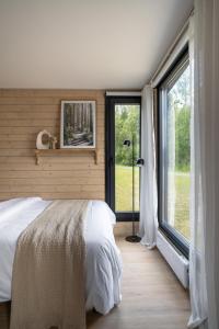 a bedroom with a bed and a large window at Palas Experience Olkkajärvi Resort in Rovaniemi
