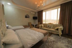 a hotel room with two beds and a couch at Hotel Harmony Premium in Kutaisi +59 photos