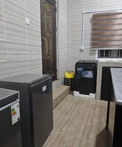 a kitchen with a stove and a door in a room at Woodlake Apartment in Dushekoro +15 photos