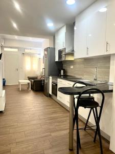 ムルシアにあるApartment next to Hospital Morales Meseguerのキッチン(白いキャビネット、テーブル、椅子付)