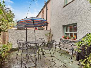 a table and chairs with an umbrella and a bench at 3 Bed in Hawkshead Village LLH34 in Hawkshead