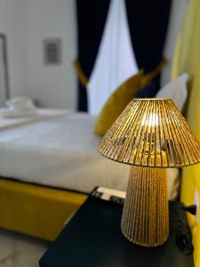 una lámpara de oro sentada en una mesa junto a una cama en RODA Apartments, en Nápoles