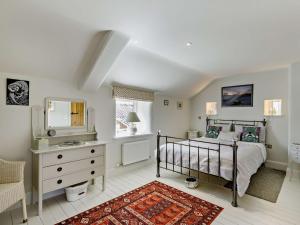 a bedroom with a bed and a dresser and a mirror at 2 Bed in Wincle PK928 in Allgreave