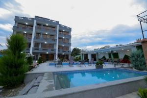 un hotel con piscina frente a un edificio en Hotel Harmony Premium, en Kutaisi