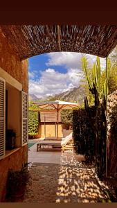 a patio with a bench and an umbrella at Luxurious finca with pool, Soller - Mallorca in Sóller +29 photos