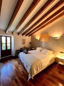 a bedroom with a large white bed with wooden floors at Luxurious finca with pool, Soller - Mallorca in Sóller +29 photos