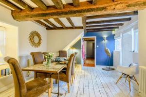 a dining room with a wooden table and chairs at Hemingford Cottage in Brancaster