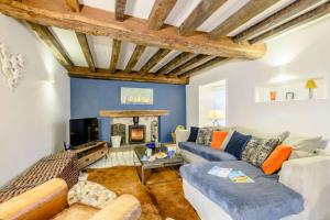 a living room with a couch and a fireplace at Hemingford Cottage in Brancaster