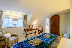a bedroom with a bed and a desk and a chair at Hemingford Cottage in Brancaster
