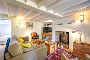 ein Wohnzimmer mit Couch und Kamin in der Unterkunft Dale Cottage in East Rudham