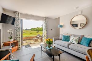 Swallows Return - Colkirk في Colkirk: غرفة معيشة مع أريكة وطاولة