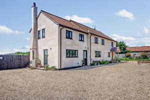 Swallows Return - Colkirk في Colkirk: منزل أبيض كبير مع ممر الحصى