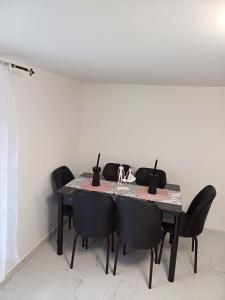 MăcinGemini house的餐桌上摆放着黑色的椅子和白色的墙壁