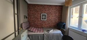 Habitación pequeña con cama y pared de ladrillo en Room best location Stockholm, en Estocolmo 1 foto más
