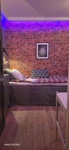 Una pared de ladrillos con una cama grande en una habitación. en Room best location Stockholm, en Estocolmo
