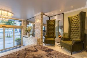 vestíbulo con 2 sillas y chimenea en Leonardo Hotel Antwerp The Plaza, en Amberes 88 fotos más