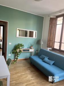 a living room with a blue couch and a table at Verdincanto Relax e comfort a due passi dal centro in Lucca